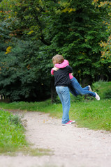 Young man holding young woman on his arms