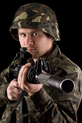 Watchful soldier aiming  m16 in studio