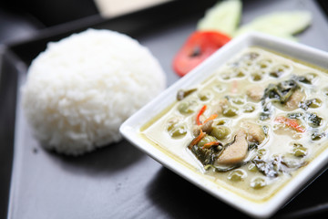 Thai food chicken green curry with rice in wood background