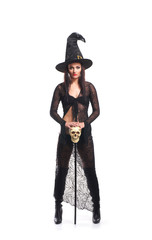 A young and sexy brunette witch in a black hat with a wand