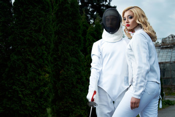 young couple in fencing costumes