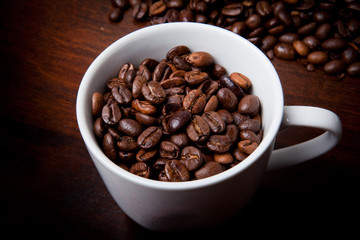Kaffeetasse mit Bohnen auf Holztisch