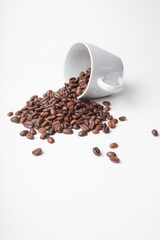 Kaffeebohnen in umgekippter Tasse