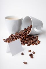 Kaffeebohnen in umgekippter Tasse mit Hinweisschild