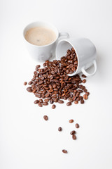 Kaffeebohne in Tasse / Umgekippt neben frischem Kaffee