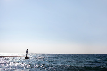 man standing at pier end