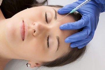 Close-up woman receives cosmetic injection with syringe
