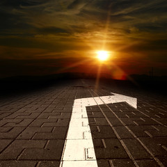 road with arrow aat the sunset