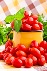 Yellow mug full of fresh cherry tomatoes