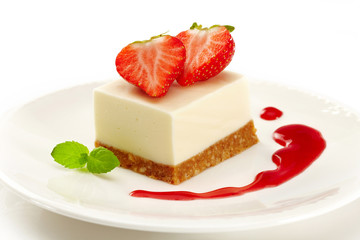 cheesecake with strawberries on white plate