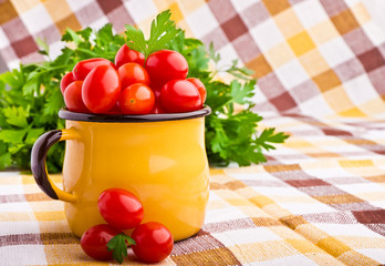 Yellow mug full of fresh cherry tomatoes