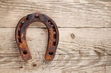 Old rusty horseshoe on wooden background