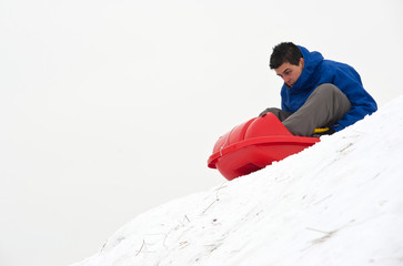Fototapeta na wymiar Młody człowiek skacząc z Bobem w śniegu.