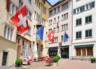 Old street in Zurich decorated with flags for the Swiss National