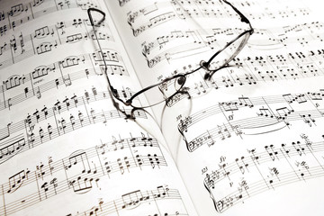 Naklejka premium heart shadow on music note book casted by eye-glasses