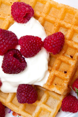waffles with wheaped cream and raspberrries