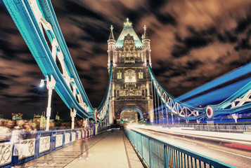 Tower Bridge in London, UK at night with traffic and moving red