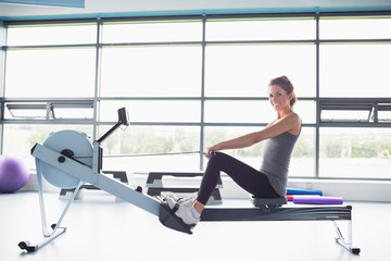 Happy woman training on row machine