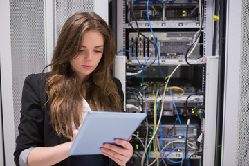 Woman using tablet pc in front of servers