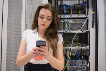 Woman texting in front of servers