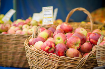 Red apples in baskets on city market