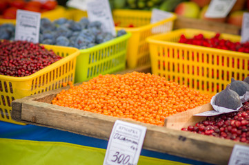 Variety of wild berries on table on city market