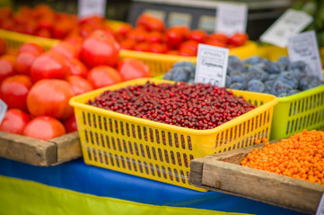 Variety of wild berries on table on city market