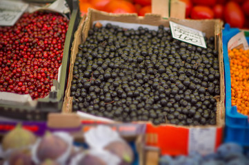 Variety of wild berries on table on city market