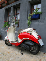 Fototapeta na wymiar Trendy motorower przed starym budynku. Fribourg, Szwajcaria