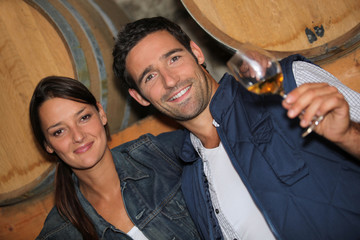 young couple tasting wine in a cellar