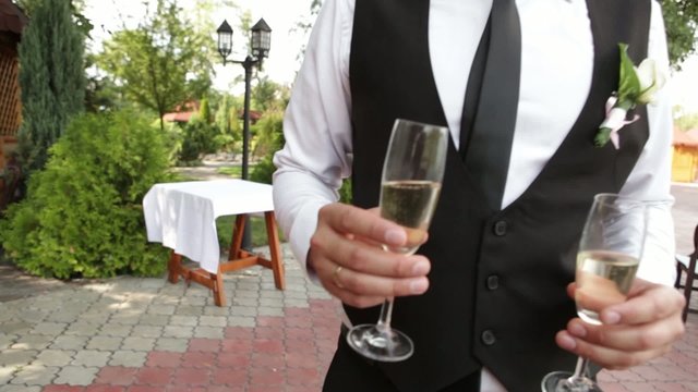 Groom carries champagne
