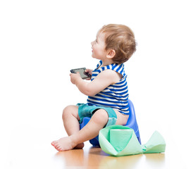 funny baby sitting on chamber pot with pda and toilet paper roll