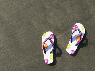  Flip-flops and hat on the black sand of Tenerife island, Canari