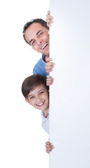 Portrait Of Father and Boy Behind Blank Board