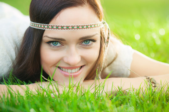 Smiling hippie girl on green grass