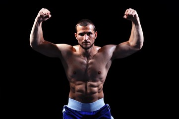 Fototapeta na wymiar Potężny muskularny bokser stwarzających na czarnym tle