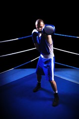 Male boxer in ring doing exercise