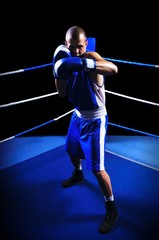 Male boxer in ring doing exercise