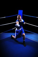 Fototapeta premium Male boxer in ring doing exercise