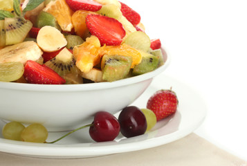 bowl with fresh fruits salad and berries isolated on white