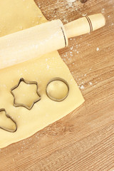 tins of cookies on the rolled out dough close-up