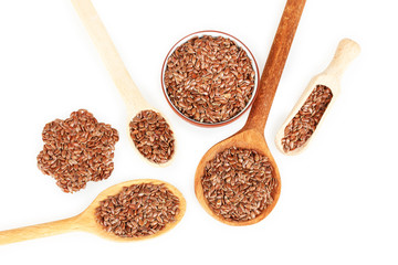 flax seeds in wooden spoons on white background close-up
