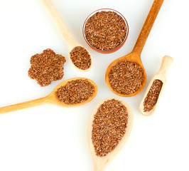 flax seeds in wooden spoons on white background close-up