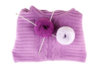 Purple sweater and a ball of wool isolated on white