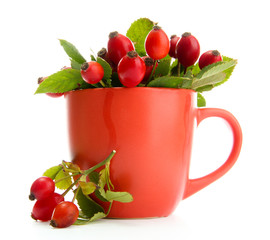 ripe hip roses with leaves in cup, isolated on white