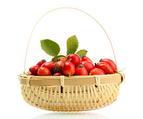 ripe hip roses with leaves in basket, isolated on white