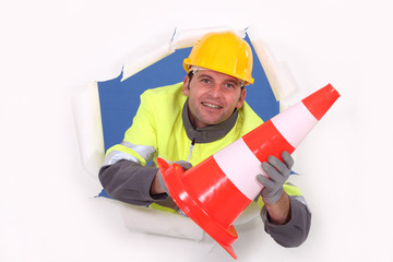 Construction worker holding a traffic pylon