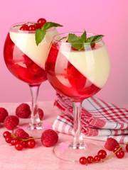 fruit jelly with berries in glasses on pink background