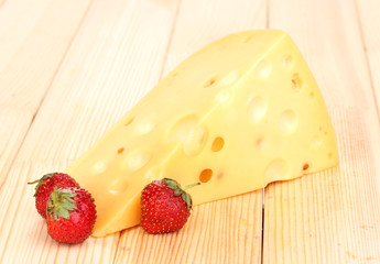 tasty cheese and berries on wooden background