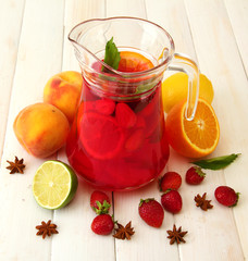 sangria in jar with fruits, on white wooden table